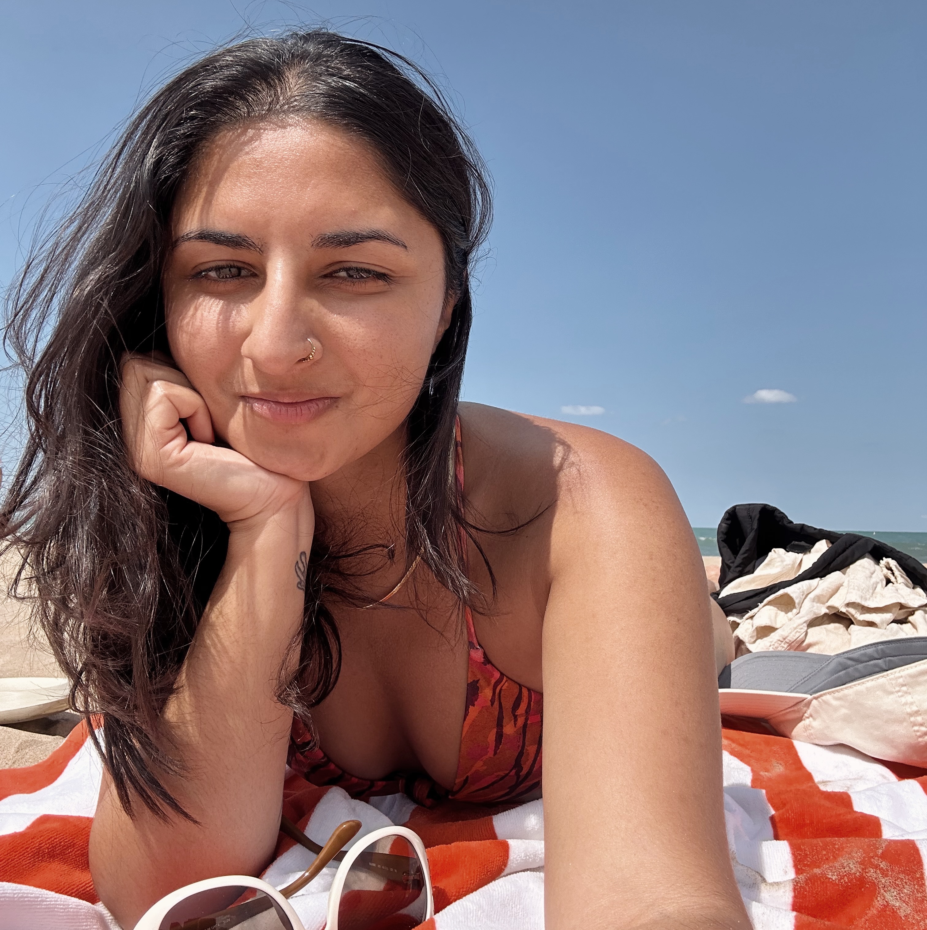 a selfie of me at the beach laying on a striped towel