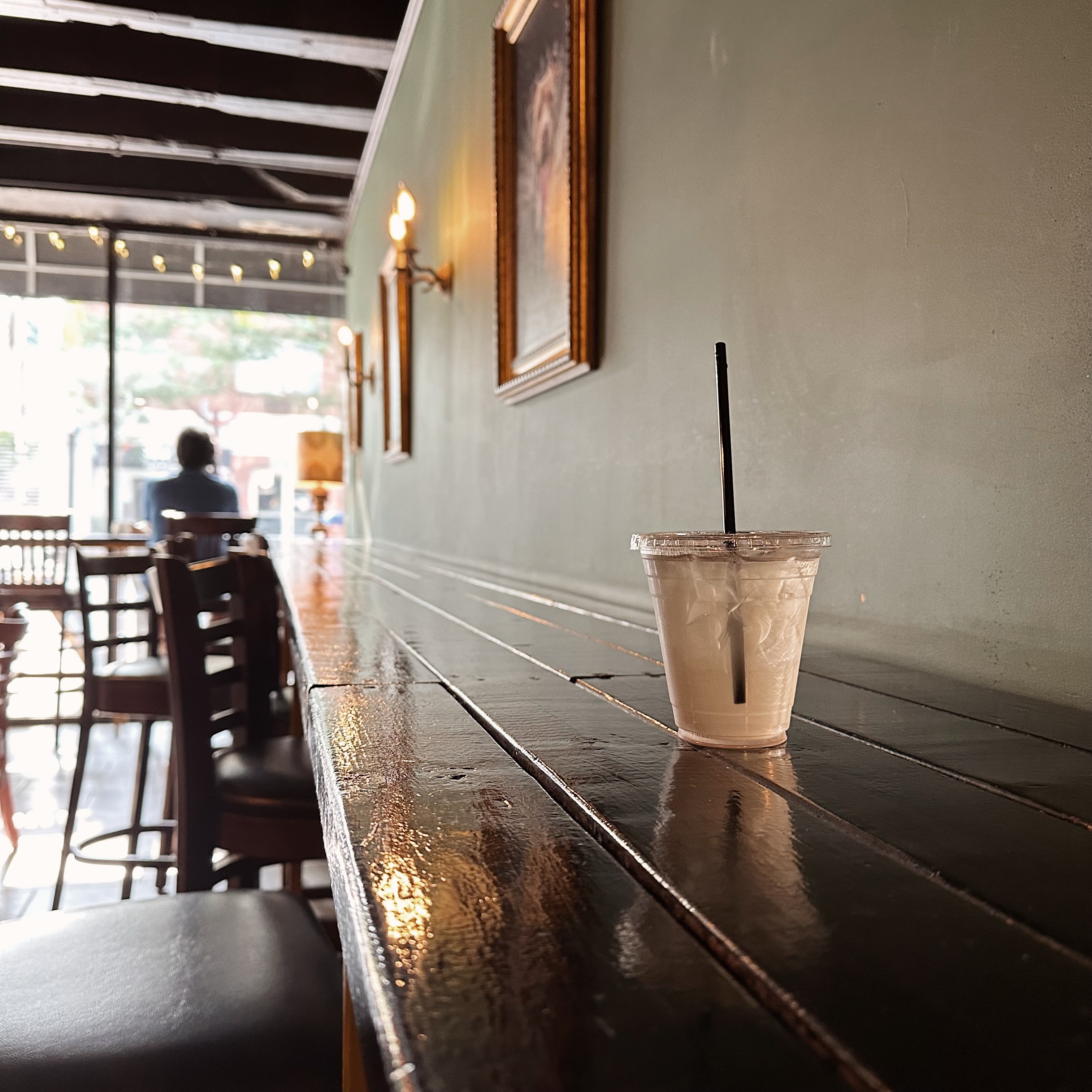 iced green tea on a long bar at a coffee shop. dimly lit image. 